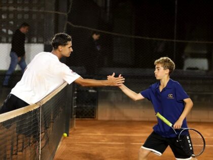 Tenistas juvenis cumprimentam-se junto à rede em quadra de saibro no Corinthians.