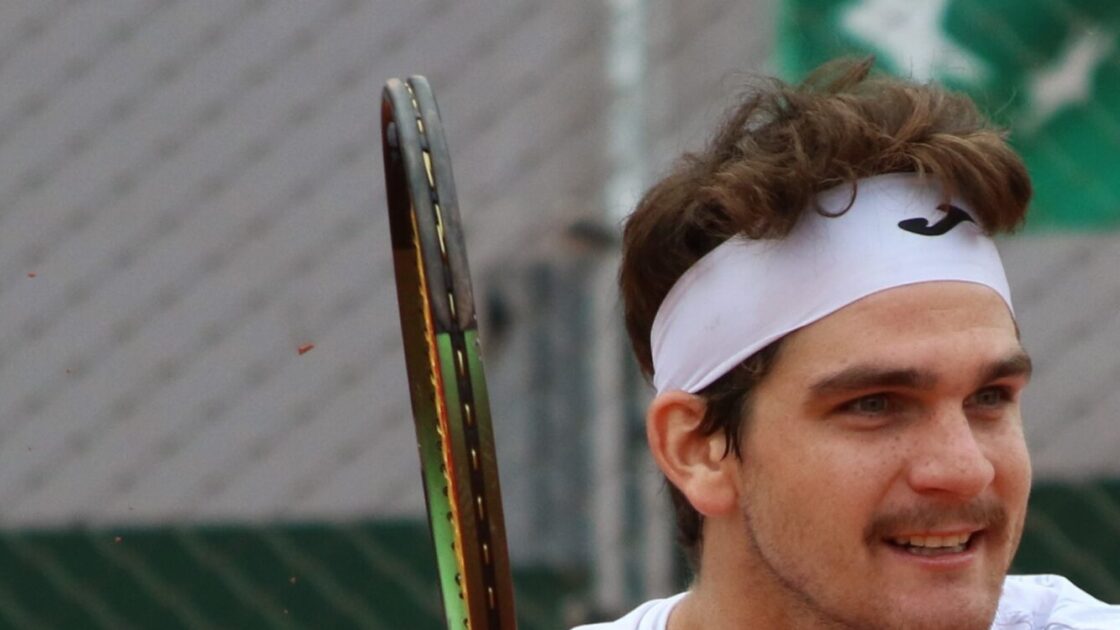 Thiago Seyboth Wild em Roland Garros 2023, com a raquete e a faixa branca na cabeça.