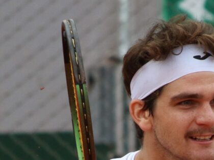 Thiago Seyboth Wild em Roland Garros 2023, com a raquete e a faixa branca na cabeça.