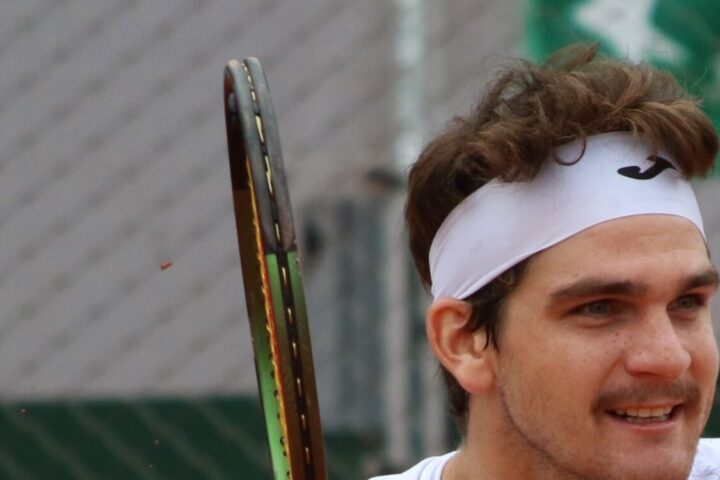Thiago Seyboth Wild em Roland Garros 2023, com a raquete e a faixa branca na cabeça.