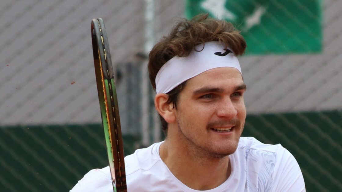 Thiago Seyboth Wild em Roland Garros 2023, com o rosto inteiro e raquete em quadra.