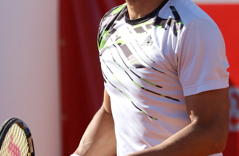 Fernando Romboli em quadra, de boné branco, com o rosto inteiro enquadrado.